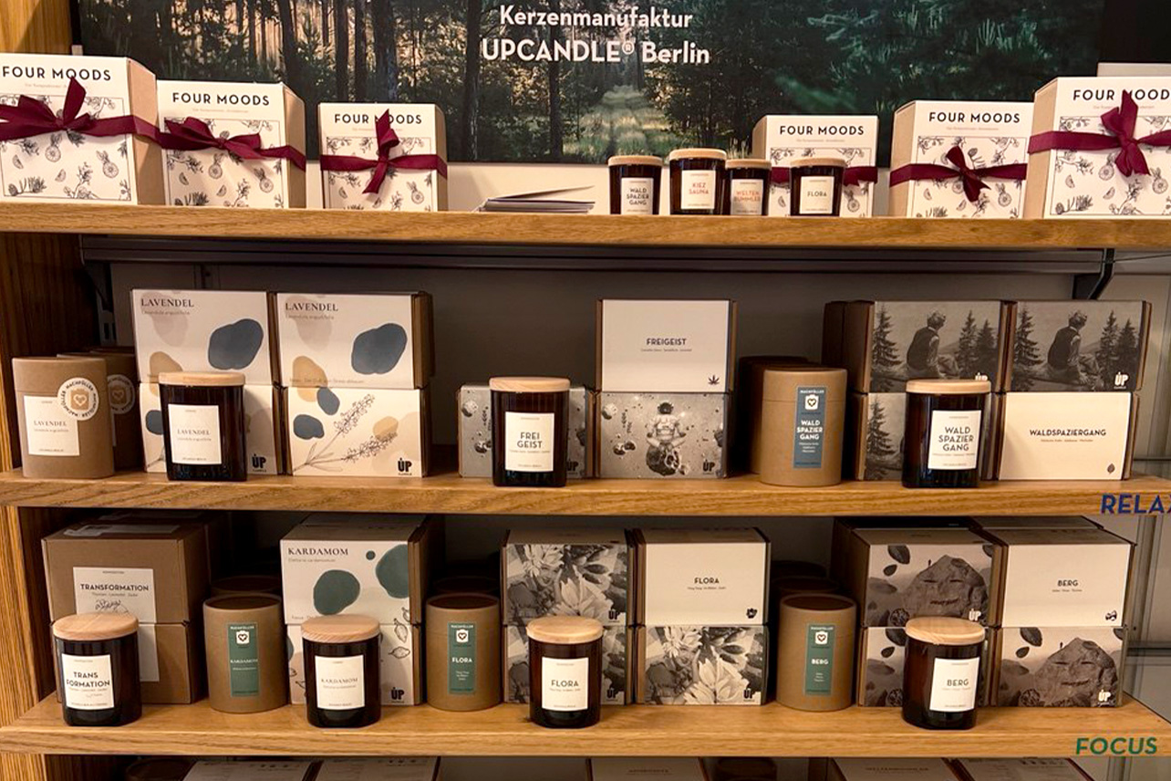 UpCandle-Verkaufsregal mit mehreren ausgestellten Duftkerzen in der Parfümerie des Breuningerland Sindelfingen